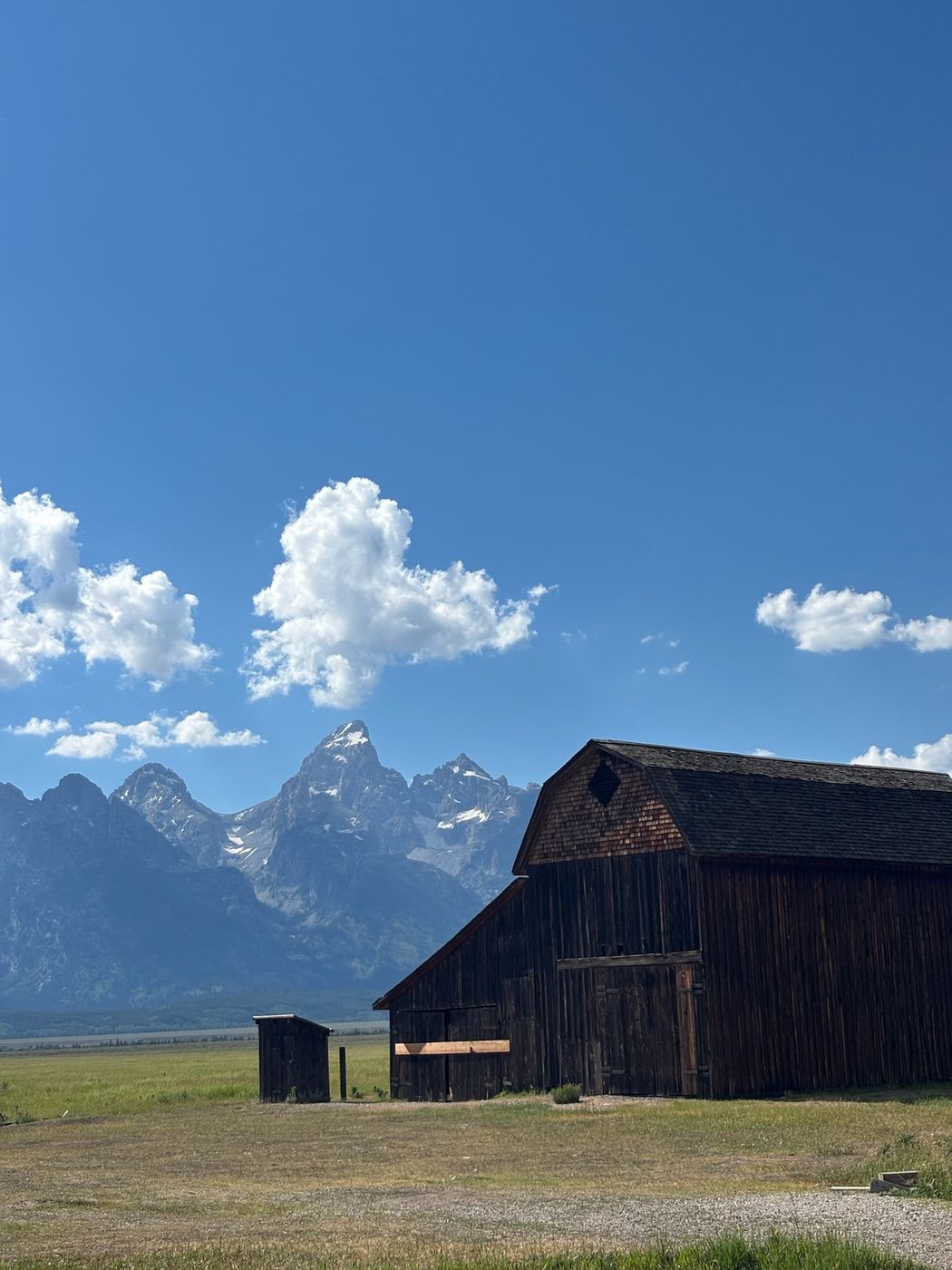 Old wooden barn below jagged mountains